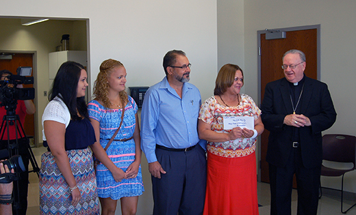 Bishop Dennis Sullivan congratulates the Cotto/Reyes family of Mary, Queen of All Saints Parish, Pennsauken on Aug. 17, when the family was presented with tickets to attend the World Meeting of Families.

Photo by James A. McBride