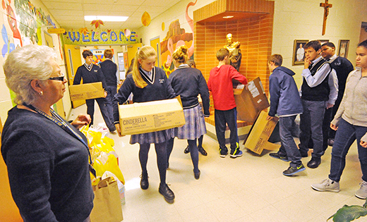 Linda Pirolli, principal of St. Vincent de Paul Regional School, Mays Landing, watches as eighth graders carry boxes of food to be delivered to the St. Vincent de Paul food pantry.

Photo by Alan M. Dumoff