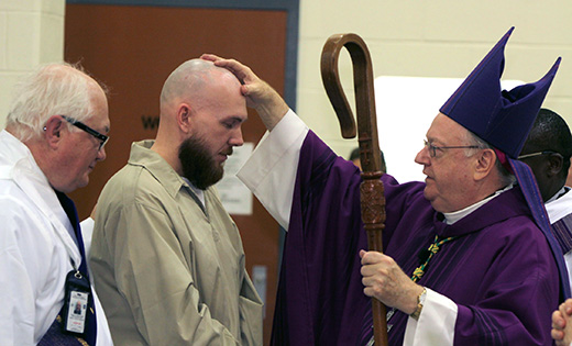 Bishop Dennis Sullivan confirms an inmate at South Woods State Prison in Cumberland County on March 23. Also pictured is Deacon Don Rogozenski.

Photo by Mike Walsh