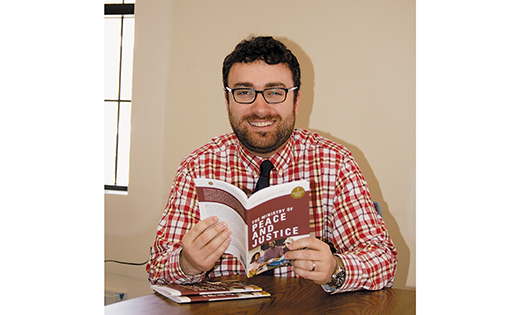 Michael Jordan Laskey, director of Life and Justice Ministries for the Diocese of Camden, looks over his newly published book, “The Ministry of Peace and Justice.”

Photo by James A. McBride