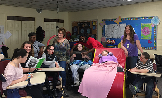 Joelle Rossi (second from left, holding book), who was named 2015 National Educator of the Year by the National Association of Private Special Education Centers (NAPSEC), is pictured with her students, assistants and a nurse at Archbishop Damiano School in Westville Grove.