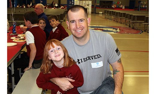 , kindergartener Mary Kate Godfrey and her father, Army veteran Christopher Godfrey, pose for a photo at the third annual Saint Michael the Archangel Regional School, Clayton, Veterans Day Breakfast on Nov. 11.