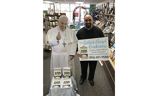 Deacon Arnaldo Santos stands next to a display with his newly-published book, “Street Gangs and God: The Battle for the Streets,” at the Littlest Angel Bookstore in Vineland.