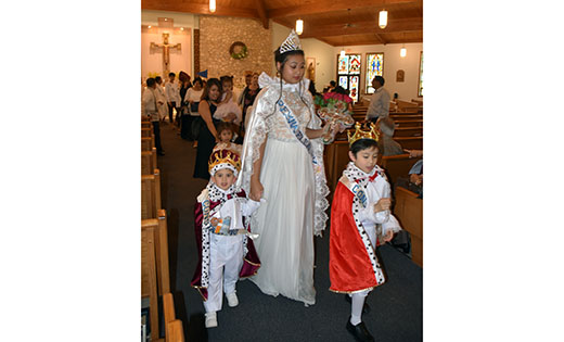 Saint Helena, whose discovery of the True Cross is symbolized by the small crucifix she carries in her arms, is portrayed by Arianna Fontanilla at the “Santacruzan” at Holy Eucharist Parish in Cherry Hill on May 21. Saint Helena is escorted by her son, the young Emperor Constantine who is almost always played by a boy in princely attire. The two boys are Brayden Micua, left, and Noah Abillar. The Santa Cruzan is a Filipino Roman Catholic religious festival held during the month of May and celebrated in honor of the Virgin Mary and Saint Helena’s discovery of the True Cross of Christ in Jerusalem around 320 A.D. It was introduced in the Philippines by the Spanish friars and continues to be celebrated by the Filipinos around the world. The celebration is sometimes referred to as Flores de Mayo (May Flowers).

Photo by James A. McBride