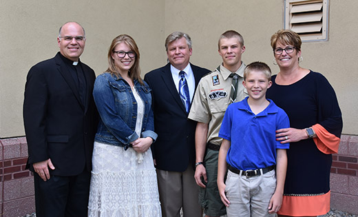 Father Nicholas Dudo stands with Jerry and Diane Vekteris of Our Lady of Perpetual Help, Galloway, and their children, from left, Alex, Andrew and Nathan. A devastating house fire renewed the family’s commitment to the church.

Photo by James A. McBride