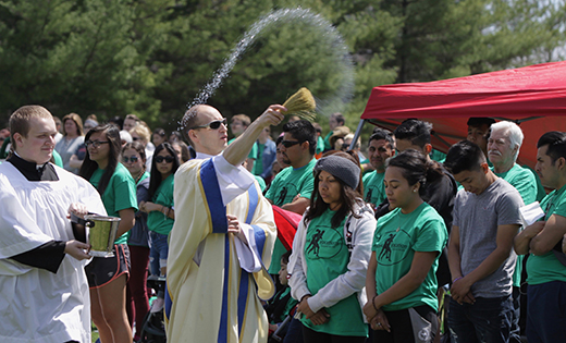 Rev. Mr. Anthony Infanti blesses those gathered on the lawn of Washington Lake Park for Mass