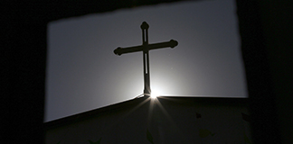 A cross atop a Catholic church is silhouetted in Tianjin, China. (CNS photo/Kim Kyung-Hoon, Reuters)
