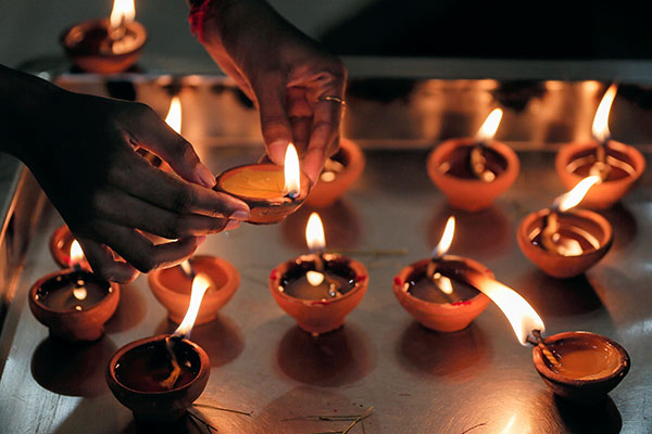 A devotee lights an oil lamp at a Hindu temple to mark the Diwali festival, amidst the spread of the coronavirus, in Colombo, Sri Lanka, in this Nov. 14, 2020, file photo. In a message marking the Hindu celebration of Diwali, the Pontifical Council for Interreligious Dialogue said Christians and Hindus can come together to bring hope to those in despair during the pandemic. (CNS photo/Dinuka Liyanawatte, Reuters)