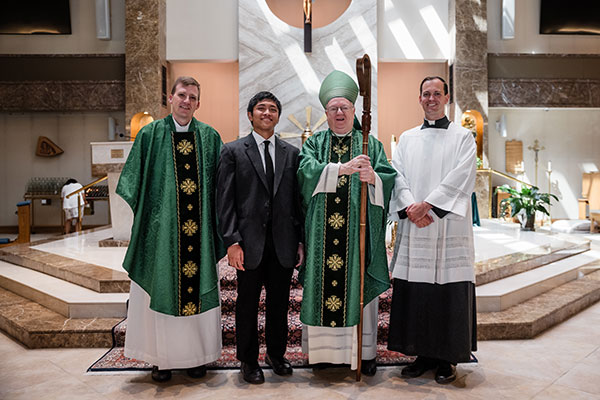 Bishop Dennis Sullivan takes a photo with the Diocese of Camden’s newest seminarian, Benjamin Suarez III, after Mass on Aug. 13 in Saint Andrew the Apostle Church, Gibbsboro. Also pictured, from left, Father Adam Cichoski, diocesan director of vocations, and Father Joshua Nevitt, associate director of vocations. (Photo by John Kalitz)