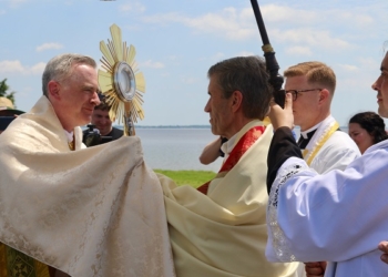 Bishop Joseph Williams receives the Blessed Sacrament from the Diocese of Wilmington’s Bishop William Koenig June 12 at Fort Mott State Park. (Photos -Mike Walsh)