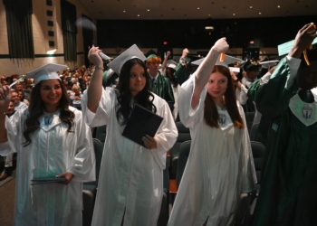 Foto por Joe Warner
Los estudiantes apartan las borlas de sus birretes hacia un lado durante la ceremonia de graduación de la escuela secundaria Camden Catholic el 5 de junio en Cherry Hill.