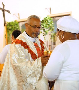 Photo by Alan M. Dumoff Msgr. Federico A. Britto, a priest of the Archdiocese of Philadelphia, accepts the offertory gifts during the annual homecoming Mass at St. Monica Church, Atlantic City, on Aug. 24. The parish was established in 1938.