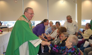 Bishop Dennis Sullivan greets people after celebrating Mass at LIFE (Living Independently for Elders) at Lourdes, Pennsauken, on Oct. 14. Pictured are Suzy Wilson (standing) of Lourdes and Irene Schmidt, Ramon Perez, Kathryn Murphy, Lucy Hamilton, Stu Finkelstein, Marge Finkelstein, Anna Houghton, Valentino Lopez and Joyce Manacek. Photo by James A. McBride 