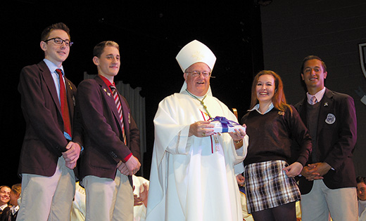 Bishop Dennis Sullivan accepts a gift at Mass at Paul VI High School, Haddon Township, on Oct. 20, a day after the former pope’s beatification and elevation to the title “Blessed.” Pictured with the bishop are seniors, Rob Helsel, Anthony Leone, Marisa Tedesco and Mike Bizzoco.

Photo by James A. McBride