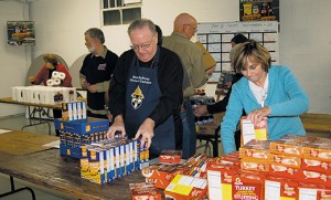 Bishop Dennis Sullivan works with members of the St. Vincent de Paul Society at Church of the Incarnation in Mantua to pack Thanksgiving baskets on Nov. 21. Photo by James A. McBride 