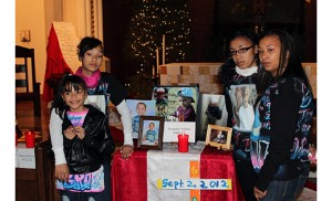 The Burgos-Andujar family stand by photos of Dominick Andujar, who was murdered when he was 6 years old, at the 2012 annual vigil for Camden murder victims. Standing at right is Dominick’s mother, Debbie Burgos. Second from left is Dominick’s sister, Amber Andujar, who was assaulted by his murderer. Sister Helen Cole and her staff at Guadalupe Family Services in North Camden work with the grieving families of murder victims.