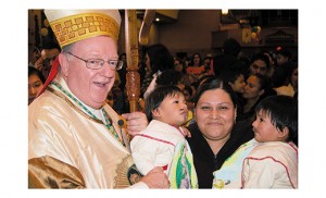 Parroquias y escuelas a lo largo de la Diócesis de Camden celebraron la fiesta de Nuestra Señora de Guadalupe, patrona de las Américas. La fiesta celebra la aparición de María al Campesino Indígena San Juan Diego en 1531 cerca de la actual ciudad de México. El Obispo Dennis Sullivan posa para una foto con una mujer y niños vestidos como Juan Diego después de la Misa de medianoche el 11 de diciembre en la Parroquia de Nuestra Señora de Guadalupe, en Lindenwold. A la derecha, el padre René Canales ora con niños ante la imagen de Nuestra Señora de Guadalupe el 14 de diciembre en la Parroquia San Gabriel Arcángel, en Atlantic City. Una mujer toma fotos de una imagen de Nuestra Señora de Guadalupe después de la Misa  el 14 de diciembre en la parroquia de Santa Gianna Beretta Molla, en Northfield.  Parishes and schools throughout the Diocese of Camden celebrated the feast of Our Lady of Guadalupe, patroness of the Americas. The feast celebrates the appearance of Mary to indigenous peasant St. Juan Diego in 1531 near present-day Mexico City. Bishop Dennis Sullivan poses for a photo with Maria Juana Lopez and Antonio and Luis Zapotitla, both dressed as Juan Diego, after midnight Mass Dec. 11 at Our Lady of Guadalupe Parish, Lindenwold; Father Rene Canales prays with children before the statue of Our Lady of Guadalupe Dec. 14 at St. Gabriel the Archangel Parish, Carneys Point; a woman photographs a statue of Our Lady of Guadalupe after Mass Dec. 14 at St. Gianna Beretta Molla Parish, Northfield. 