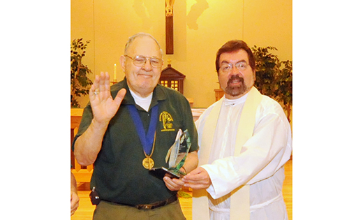 Andy Wager accepts the Bishop’s Scouter Award from Father Paul D. Harte in 2009. He was the first recipient of the award.