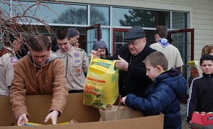 Photo by James A. McBride Bishop Sullivan helps load a truck with donated food during the FaithFULL food drive on March 1.