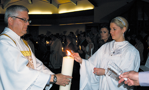 Crystal Jeffries receives light from the Paschal Candle held by Deacon William Slaven during the Easter Vigil April 4 at St. Andrew the Apostle Parish in Gibbsboro. Celebrated by Bishop Dennis Sullivan, the vigil at St. Andrew’s joined other Christian communities around the world in recalling Jesus’ Resurrection. Jeffries, a catechumen in the parish’s Rite of Christian Initiation of Adults (RCIA), received the sacraments of initiation during the vigil and entered into full communion with the Catholic Church.

Photo by James A. McBride