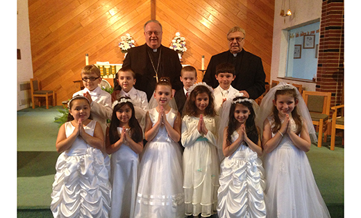 Bishop Dennis Sullivan and Msgr. Joseph V. DiMauro, pastor of Holy Angels Parish, Woodbury, stand with children following the May crowning at Holy Trinity Regional School, Westville Grove, on May 21. The month of May is devoted to Mary and is traditionally celebrated with a crowning and praying of the rosary.

Photo by Father Michael M. Romano