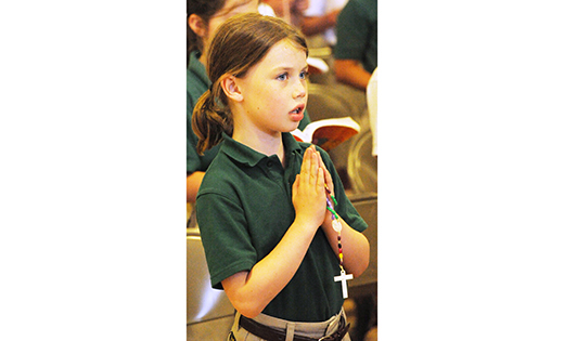Imogene Nuss, a third grade student at Bishop McHugh Regional School, Cape May Court House, prays the rosary May 19 during a prayer service when the International Pilgrim Virgin Statue of Our Lady of Fatima was brought to the school.

Photo by Alan M. Dumoff