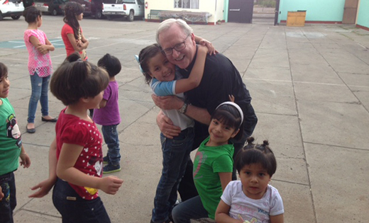 Father Vincent G. Guest is pictured with children of an orphanage in Mexico.