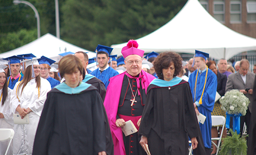 Bishop Dennis Sullivan walks with the faculty on the football field of Paul VI High School, Haddon Township, for the commencement ceremony on June 3. Below, he poses for photos with graduates of St. Joseph High School, Hammonton, on June 4. Also pictured are Father Christopher M. Markellos, Director of Catholic Identity at the school, and Father Michael M. Romano.

Photo above by James A. McBride