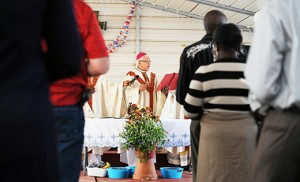 Containers filled with freshly picked blueberries sit in front of the altar as Retired Auxiliary Bishop Guy A. Sansaricq of Brooklyn celebrates a Mass of welcome for Haitian migrant farm workers at Columbia Fruit Farm in Hammonton on June 26. Photo by Alan M. Dumoff