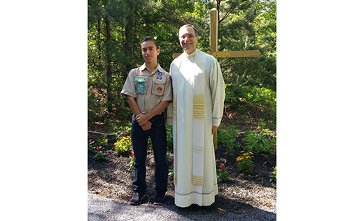 Father John Vignone, pastor of St. Katharine Drexel, Egg Harbor Township, stands with Vito Acosta, who, with the help of volunteers, created a prayer path at the parish for his Eagle Scout project.