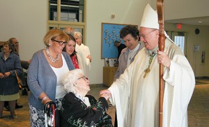 Bishop Dennis Sullivan greets Doris Hellmund at St. Thomas More Parish, Cherry Hil, in April 2014. The sale of the nursing homes is expected to help the Camden Diocese community-based ministries of care for seniors and other groups. “Future trends resulting from the government’s managed-care programs, whose goal is to enable people to remain in their homes and receive needed care there, reinforced this conclusion,” said Deacon Gerard Jablonowski, PT, MS, the director of Home and Parish-Based Services for the diocese. Photo by James A. McBride