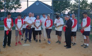 Photo by James A. McBride Men and women from St. Rose of Lima Parish, Haddon Heights proved to be champions on the diamond as they defeated Our Lady of Hope, Blackwood, 22-14, in the title game of the Camden Diocese Co-Ed Softball League, played Aug. 3 in Blackwood.  Father Joseph Byerley, St. Rose of Lima pastor, led the team in prayer after their victory.