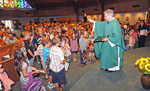 Father Perry Cherubini, pastor, blesses the backpacks of students at the family Mass at St. Elizabeth Ann Seton Church, Absecon, on Sept. 6.

Photo by Alan M. Dumoff, more photos ccdphotolibrary.smugmug.com