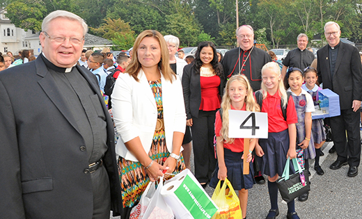Photo by Alan M. Dumoff, more photos , ccdphotolibrary.smugmug.com
Clergy as well as school staff were on hand to welcome students for the first day of the new school year at Bishop Schad Regional School, Vineland, on Wednesday, Sept. 2. Standing with the children are, from left, Msgr. John H. Burton, pastor of Christ the Good Shepherd Parish, Vineland; fourth grade teacher Dina Strain; Mary P. Boyle (partially obscured), superintendent of schools for the Diocese of Camden; Marianela Nuñez, field consultant for the Latino Enrollment Program; Bishop Dennis Sullivan; Father Edward M. Friel, parochial vicar, Christ the Good Shepherd; and Father Vincent G. Guest, pastor of Holy Cross Parish, Bridgeton.