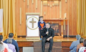Fotos por alan M. Dumoff Una niña se une al Padre Jaime Pérez en el escenario durante su predicación principal. A child joins Father Jaime Perez on stage during his keynote address.