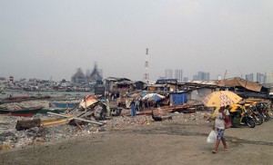 A woman walks along the Pasig River in a neighborhood called Baseco, Manila’s poorest slum. Trash carried in the river, which cuts through all of Manila, winds up on the shores of Baseco, which is located at the mouth of the Pasig on Manila Bay. Photo by Joanna Gardner