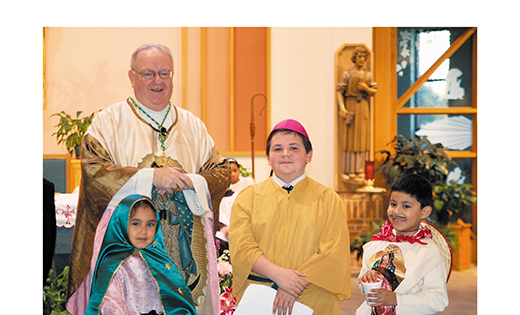Bishop Dennis Sullivan lets sixth grader Tyler Strickland, who portrayed a Mexican bishop in a skit about Our Lady of Guadalupe, wear his zucchetto, the skullcap worn by Catholic clergy. First grader Jackelin Rangel took the part of Our Lady of Guadalupe, and Christian Rangel, also a first grader, was Juan Diego at Saint Luke Church in Stratford, part of Our Lady of Guadalupe Parish, Lindenwold. The children are students of John Paul II Regional School, Stratford.

Photo by James A. McBride