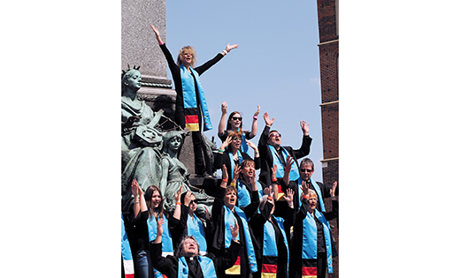 Father Krzysztof Wtorek, pictured at bottom, has assembled a group of singers and musicians from three counties who will perform at World Youth Day in Poland in July. The group is pictured here singing at the base of a statue of Polish poet Adam Mickiewicz, located at the main square in Krakow, Poland. The area is a famous gathering place for young people.
Photo by Ekkehard Heim