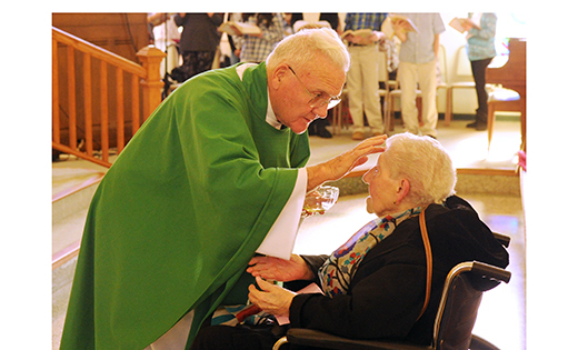 Father Patrick J. Brady, a retired pastor of the Camden Diocese, anoints Ann Flammer during Mass with the sacrament of anointing of the sick on Jan. 31 at Saint Joseph Church, Somers Point. Bottom, Father Josef A. Wagenhoffer, also a retired pastor, prays with a woman. The Mass was sponsored by the parish nursing ministry and the Knights of Columbus Council 10220.
Photos by Alan M. Dumoff