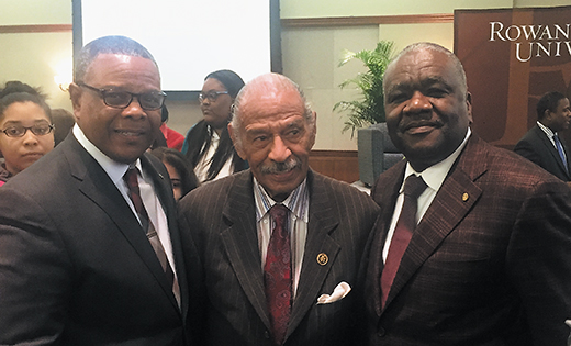 Curtis H. Johnson, left, and James E. Andrews, right, stand with Rep. John James Conyers, Jr. at a Black History Month program. Conyers was the keynote speaker.