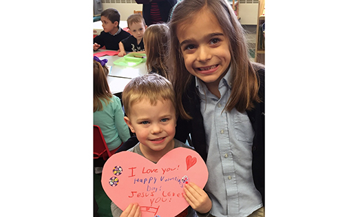 Cooper Chambers and Sarah Yucis show one of the valentines that the pre-K and second grade students of Guardian Angels Regional School, Gibbstown, made for the residents of Twin Cedars Assisted Living in Woodbury.