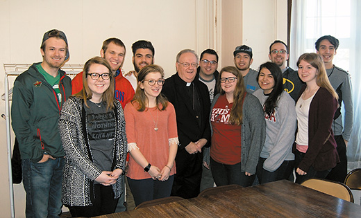 Bishop Dennis Sullivan poses for a photo at Holy Angels Parish in Woodbury with a dozen missionaries from the National Evangelization Team.