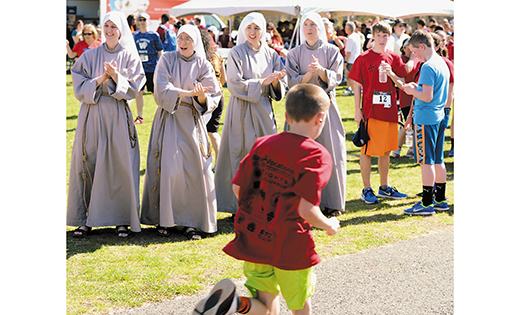 The fifth annual iRace4Vocations took place Sunday afternoon, April 17, at Sewell’s Washington Lake Park, bringing together families, clergy and religious, and seminarians to pray and put on their running shoes for vocations. Above, members of the Franciscan Sisters of the Renewal, making the trip from New York, cheer on the racers.

Photo by Alan M. Dumoff