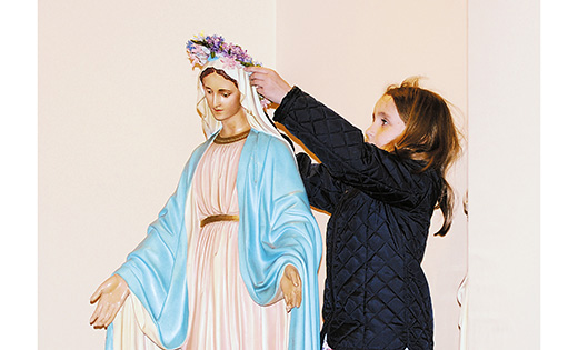 Cassidy Costello, 7, crowns a statue of Mary May 6 at Holy Child Parish, Runnemede. During the month of May many parishes and schools conduct Marian devotions.

Photo by Alan M. Dumoff