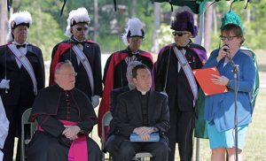 Bishop Dennis Sullivan and Father Michael Romano listen as South Jersey Catholic Cemeteries director Marianne Linka speaks at the dedication ceremony at the newly expanded Gate of Heaven Cemetery in Berlin on June 22. Below, the bishop blesses a crucifix on the grounds.