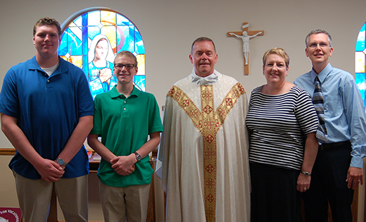 Father Raymond Gormley, pastor of the Church of the Incarnation in Mantua, stands with Doug and Joan Stetser and their sons, Andrew, far left, and Adam. “By volunteering in a ministry, you make it a part of your life. The more you give, the more you receive,” says Joan.

Photo by James A. McBride