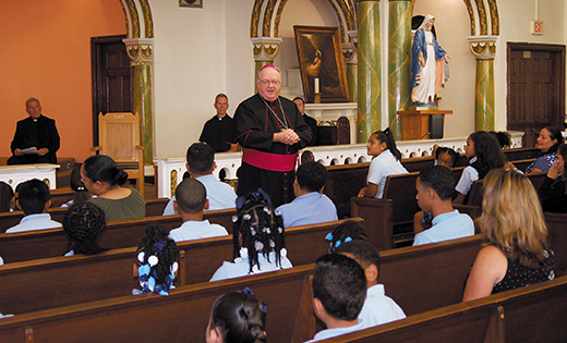 Bishop Dennis Sullivan speaks to students in Holy Name Church during a visit to Holy Name School, Camden, on Sept. 8.

Photo by James A. McBride