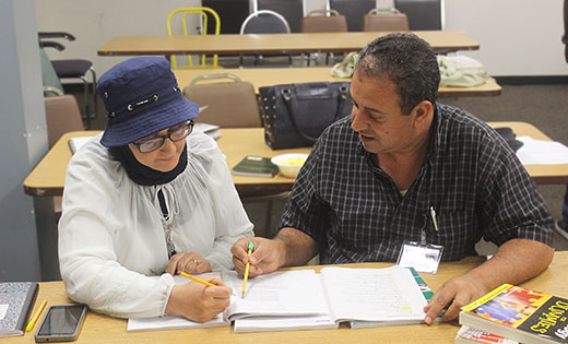 Tarek Mousa, who teaches English as a Second Language through Catholic Charities, works with Rawnak Hazim, one of 45 students currently part of the ESL program with him. Hazim, a refugee originally from Iraq, walks an hour to attend classes at the Catholic Charities Camden office.

Photo by Mary McCusker