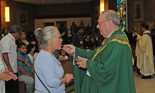 Bishop Dennis Sullivan distributes Communion at the Hispanic Catholic celebration at Divine Mercy Parish, Vineland, on Sept. 18.