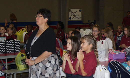 Pictured are students of Saint Michael the Archangel Regional School, Clayton, on the first day back to school, Sept. 6. In the above photo, Janice Bruni, principal, leads students in prayer; in the photo below, third grade students smile for the camera as they wait for the bell to ring.

Photos by Mike Walsh